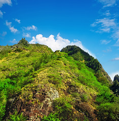 Image showing Mountain, green and natural landscape with blue sky, summer and calm clouds on peak at travel location. Nature, cliff and sustainable environment with earth, forest and tropical holiday destination