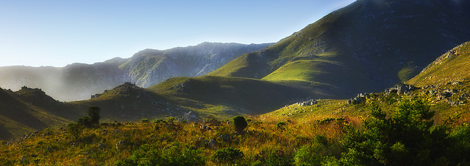 Image showing Mountain, fog and natural hill with field, blue sky and calm landscape for travel location. Nature, green and sustainable environment with earth, peace and holiday destination with conservation