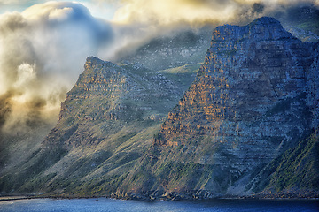 Image showing Mountain, clouds and sunset at ocean cliff with natural landscape, hill and beach at travel location. Nature, cloudy sky and sustainable environment with earth, sea and island holiday destination