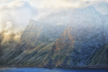 Image showing Mountain, clouds and fog at ocean cliff with natural landscape, hill and calm beach at travel location. Nature, cloudy sky and sustainable environment with earth, sea and island holiday destination