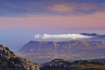 Image showing Mountains, color and natural landscape with cloudy sky, sunset and calm cliff at travel location. Nature, island and sustainable environment with earth, peace and pink tropical holiday destination