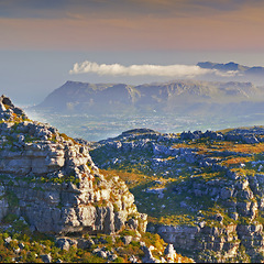 Image showing Mountain, fog and natural landscape with cloudy sky, sunset and calm cliff at travel location. Nature, peak and sustainable environment with earth, peace and holiday destination with tropical island