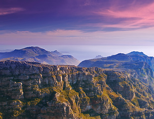 Image showing Mountain, clouds and sunset sky with color on horizon, natural landscape and cliff at travel location. Nature, hill and sustainable environment with earth, peace and destination at tropical island