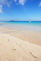 Image showing Ocean, Bali and blue sky for holiday, sand and rocks in shore for peace and tranquility. Seaside, waves and summer for vacation, location and beach for clear water on travel and tropical trip