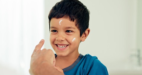 Image showing Boy, skincare laugh and lotion with a smile from morning routine and cream with cosmetics. Happy, kid and moisturizer with youth in a family home and bathroom with sunscreen, cheerful and facial care