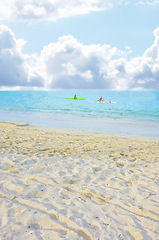 Image showing People in ocean, kayak and beach for vacation in Hawaii, nature and environment with gold sand for travel. Adventure, sports and fun in sea with coastline or shore, clouds and blue sky in summer