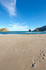 Image showing Beach sand, blue sky and ocean, landscape with nature and environment, coastline and travel destination. Horizon, waves and seascape with natural background, tropical location or island for holiday