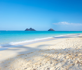 Image showing Ocean, mountain and blue sky for holiday, sand and rocks in Hawaii for peace and tranquility. Seaside, waves and summer for vacation, location and beach for clear water on travel and tropical trip