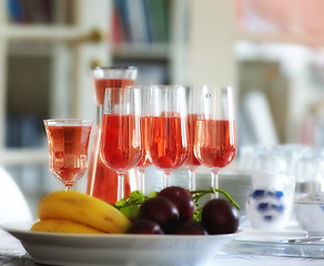 Image showing Red, wine and fruit bowl in home, table with alcohol drink and glasses for guests. Hostess and preparation for celebration, events and holiday culture for relax with sangria for cocktail party