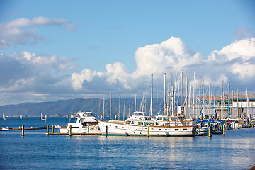 Image showing Harbor, ship and port in nature outdoors, travel and yacht on holiday or vacation or location. Marina, seaside and boat on water for peace or calm at dock, cruise transport and ocean or sea on island