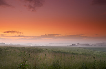 Image showing Sunset, fog or field of grass in countryside, pasture or scenery for landscape, banner or wallpaper. Mist, dramatic sky or sunlight for mystical, rural or panorama of peaceful grassland screen saver