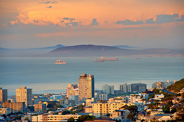 Image showing City, building and ocean sunset with development infrastructure for summer holiday, explore or downtown. Water, urban and sea or mountain in South Africa or calm nature or evening, vacation or trip