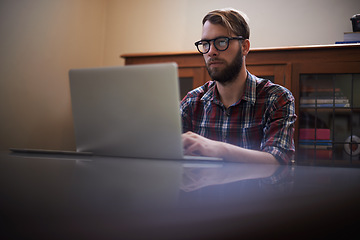 Image showing Man, laptop and journalist with glasses in remote work, communication or networking at home. Male person, writer or freelancer working and typing on computer for online story or blog at the house