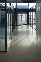 Image showing Office, interior and hallway with glass windows in passage or corridor of modern workplace. Empty corporate building, structure or clean floor with walls of business architecture or industrial design
