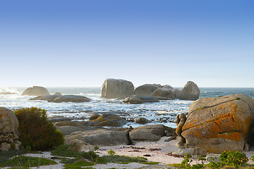 Image showing Nature, landscape and rocks by ocean in South Africa for travel destination, holiday and vacation. Natural background, summer and waves, sea and boulders for scenic view, environment and location