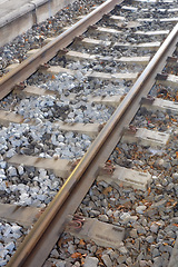 Image showing Railway, track and stone on ground for train, transport and commute on earth in environment. Metal, lines and pebbles for travel, move and carriage for engine, locomotive or journey in industry