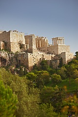 Image showing Architecture, artistic building and history of parthenon in Athens Acropolis with trees, nature and grass in Greece. Traditional temple, design and walls in landscape blue sky, rocks and marble