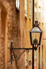 Image showing Travel, architecture and lamp on vintage building in old town with history, culture or holiday destination in Sweden. Vacation, landmark and antique lantern in Stockholm with retro light ancient city