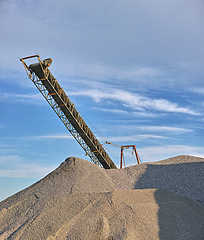 Image showing Crane, sand and machine with blue sky at construction site for building of foundation, bricklaying and landscape project. Closeup, industrial equipment and vehicle for business, ground work and job