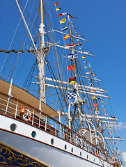 Image showing Ship, water and harbor at sea to coast guard with landscape, blue sky and nautical flags for emergency sailing. Vessel, dock and ocean with safety for maritime, danger and patrol in morning or nature