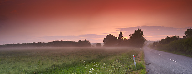 Image showing Road, field and nature landscape or farm environment at sunset or countryside travel, journey or sustainable. Street, grassland and forest as panorama scenery or outdoor in England, fog or meadow