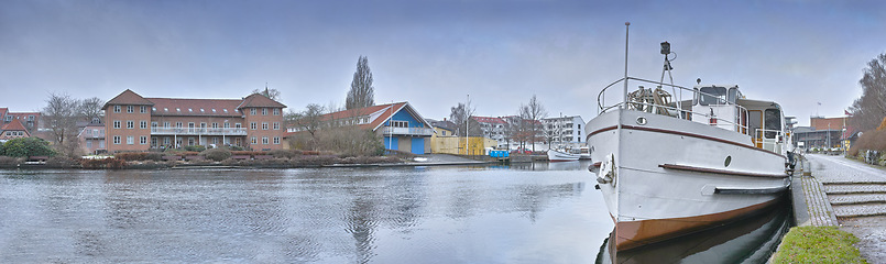 Image showing Harbor, ship and town in nature outdoors, travel and yacht on holiday or vacation or location. City, seaside and boat on water for peace or calm in Silkeborg, Denmark and river or lake on getaway