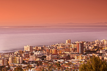 Image showing Drone, city and buildings with travel and sunset, architecture and skyscraper with outdoor landscape. Property, real estate and urban development, pink sky in location with aerial view and background