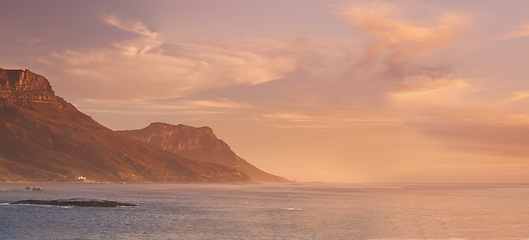 Image showing Landscape, ocean and sunset background by mountains for environment, travel or adventure. Banner of the sea in nature with clouds, golden light and paradise and island for holiday, art and vacation