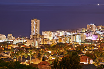 Image showing Night, city and buildings with travel and view, architecture and skyscraper with outdoor landscape. Property, real estate and urban development, destination or location with skyline and background