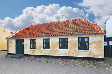 Image showing Retro house, home and real estate in countryside with clouds, sky and building on street in Denmark. Vintage architecture, mortgage and Danish residence for lodging, living and old village in Europe