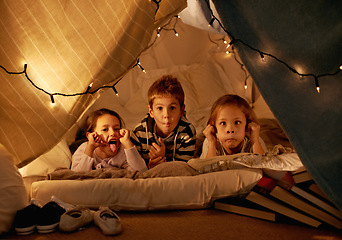 Image showing Children, happy and playing in blanket fort with funny face for fantasy, bonding and string lights at night. Friends, kids and comic gesture for pajama party, sleepover and pillow tent with lighting