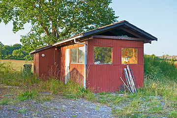 Image showing Countryside, grass and field with broken cabin with vintage architecture on neighborhood in Texas. Ghost town, countryside and house with rust in quiet community with nature and woods in village