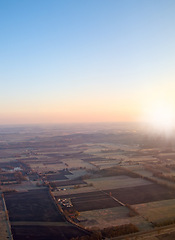 Image showing Town, aerial view and countryside in outdoors at sunset, field and sustainable environment on travel. Blue sky, peace and mockup space in nature, drone and town for ecosystem at dusk or landscape