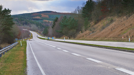 Image showing Mountain, road trip and forest landscape for travel, holiday and green scenery with trees in Denmark. Nature, cloudy sky and highway for journey, vacation and outdoor adventure in natural environment