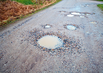 Image showing Water, gravel and road in countryside with pothole with maintenance, infrastructure and farm transport in winter. Dirt, path and rain puddle in hole on rural street with damage, ground and nature.