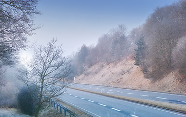Image showing Highway, road trip and desert landscape for winter travel, holiday or natural scenery in countryside. Nature, trees and street for journey, vacation or outdoor adventure with sky, relax and adventure
