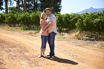 Image showing Couple, portrait or hug outdoor in countryside, wine farm or vineyard for love, care or holiday. People, husband and wife embrace together at winery, nature or environment with vines, plants or trees