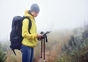 Image showing Woman, hiker and reading map on trail in nature, fog and guide for direction on mountain path. Sports gear in bag for supplies, adventure or fitness with natural winter for health in winter peace