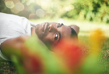 Image showing Man, portrait and lying on grass while resting, smile and enjoy summer or outdoor. Black person, relax and sunshine after holiday or vacation, comfortable and happiness in park or nature flare