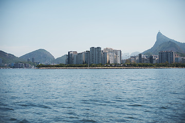 Image showing Ocean, city and seascape with mountain, sky and buildings on cityscape, water and outdoor in urban Cape Town. Landscape, sea and coast in blue skyline, beach and summer for travel, nature and view