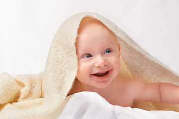 Image showing Baby, smile or towel to play, relax or laugh in nursery at bath time in studio on white background. Happy, young child or blanket for peaceful rest for health, hygiene or childhood development