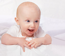 Image showing Baby, excited and smile with laying on bed for curiosity, child development and relax on bed at house. Adorable, kid and cute infant in home for playful, laugh and fun with happiness in nursery