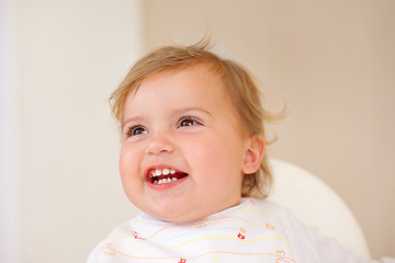 Image showing Baby, smile and laughing for fun, play and watch of game and joke as sitting in high chair in home. Happy, young or child for joy, positive or humor for healthy growth or early childhood development