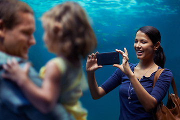 Image showing Aquarium, woman or phone for photo, family or outing for fun, happy or bonding together in Brazil. People, smartphone and fish tank for social media, exploration and marine life on playful weekend