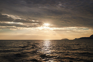 Image showing Sunset, nature and ocean with landscape and horizon, environment for travel and vacation location. Clouds, sky and water with tourism destination, natural background or seascape with waves and calm