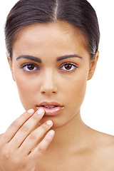 Image showing Girl, serious and dermatology for skincare in studio as model in white background for woman. Female person, beauty and hand on her lips with lipgloss from cosmetics for self care and brunette hair