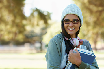 Image showing Thinking, student and happy woman in park with books for studying, learning and reading outdoors. Education, college and person with smile, textbooks and headphones relax in nature for university