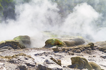 Image showing Rocks, smoke or vapor in nature with landscape, sulphuric pool or volcano in environment. Steam, mist and fog with heat from natural hot spring, Earth and stone with mountain for travel or tourism