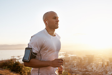 Image showing Man, running and sunset with earphones on mountain for workout, exercise or cardio training. Active male person or runner listening to music, podcast or audio for motivation in health and wellness