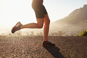 Image showing Legs, shoes and person running outdoor in city, cardio and fitness for health and wellness at sunrise. Athlete, marathon and speed with runner on road for exercise, workout and training in morning